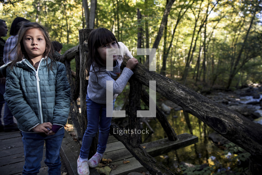 Little girls walking on a wood bridge