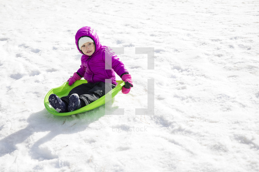 a child in a snowsuit playing outdoors 