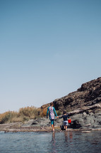 Young boy and girl exploring Wadi Al Khoudh, a popular wadi located next to the old Al Khoudh Village in Muscat, Oman.