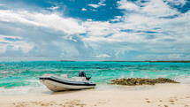beached boat on a shoreline with turquoise waters