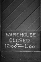 "Warehouse closed" sign on a wood door.