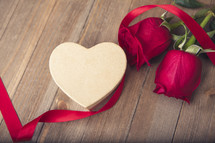 heart shaped gift box, red ribbon, and red roses 