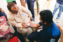 healthcare and medicine - man getting his blood pressure checked 