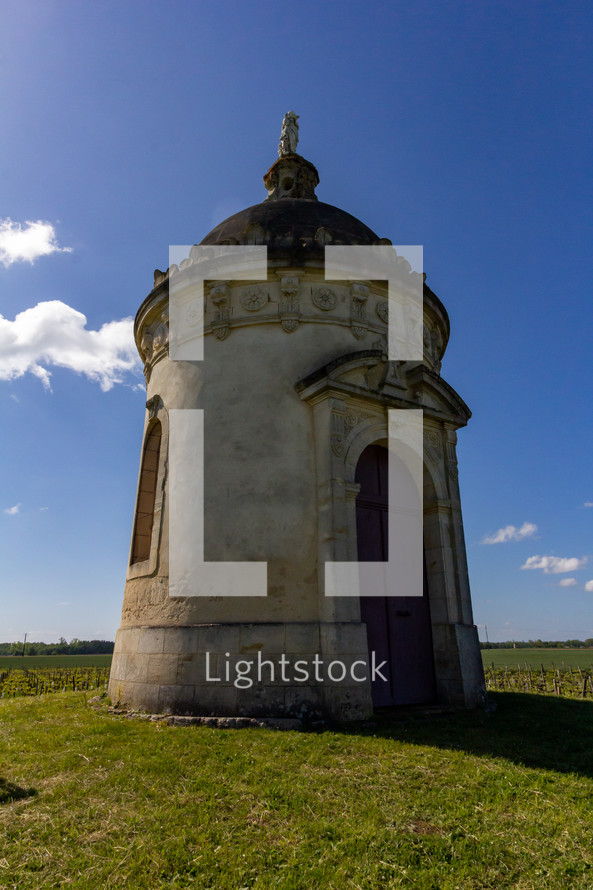 Found in the middle of a Bordeaux vineyard, a round tower chapel stands on a small hill