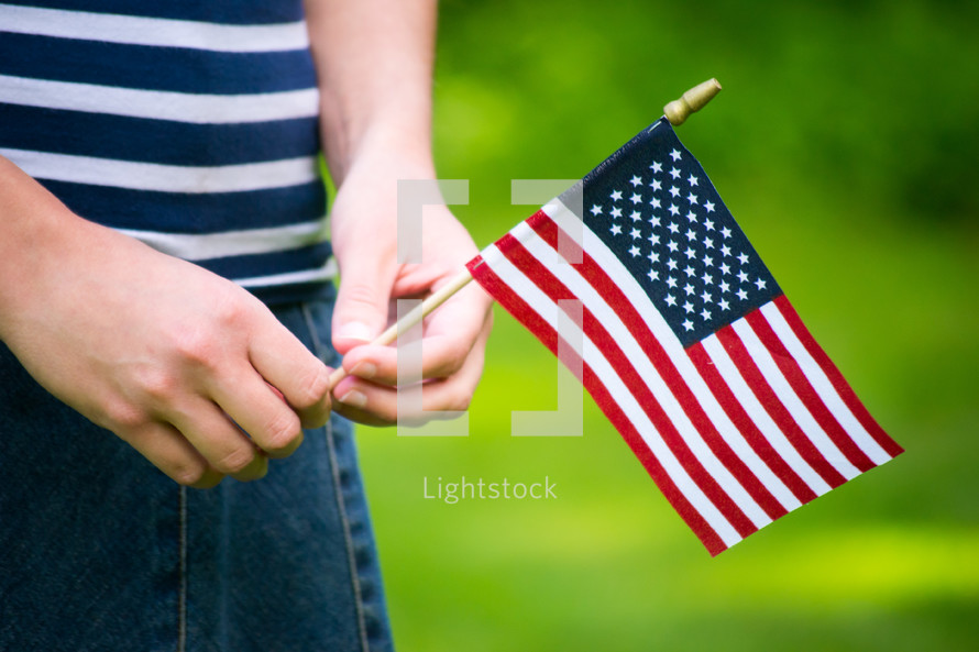 a girl holding a small American flag  