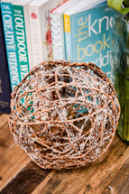 books and a decorative ball of sticks 