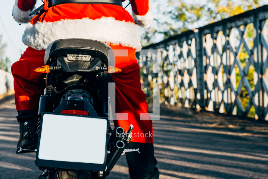 Santa on a motorcycle with a blank sign on the back 