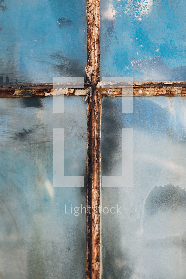 rusty window pane in shape of the cross