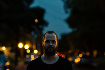 man with a beard and lights in the background 