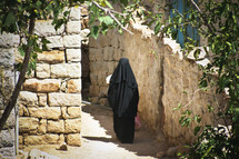 A woman in a burka walking through the streets of Yemen