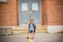 a cheering boy near school doors 