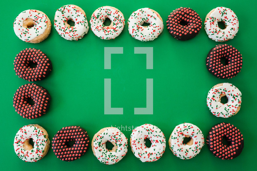 Christmas donuts frame on green 