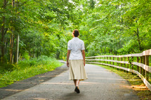 a woman walking on a paved path 