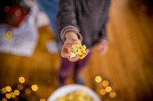 a child offering popcorn 