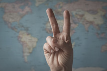peace sign in front of a world map 