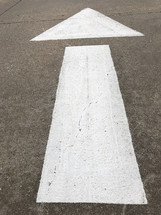arrow painted with stencil on roadway, giving direction