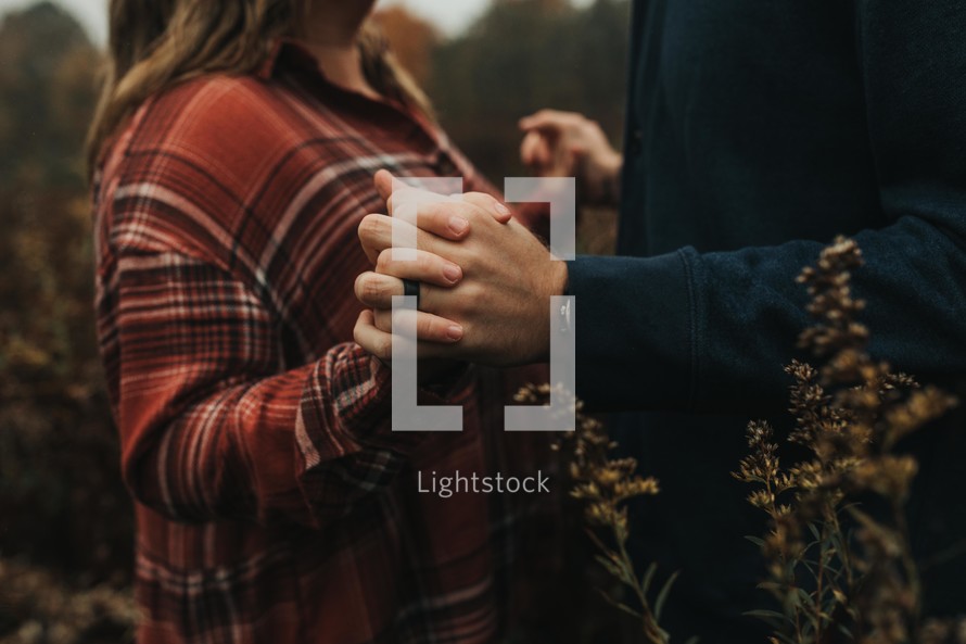 a couple holding hands outdoors in fall 