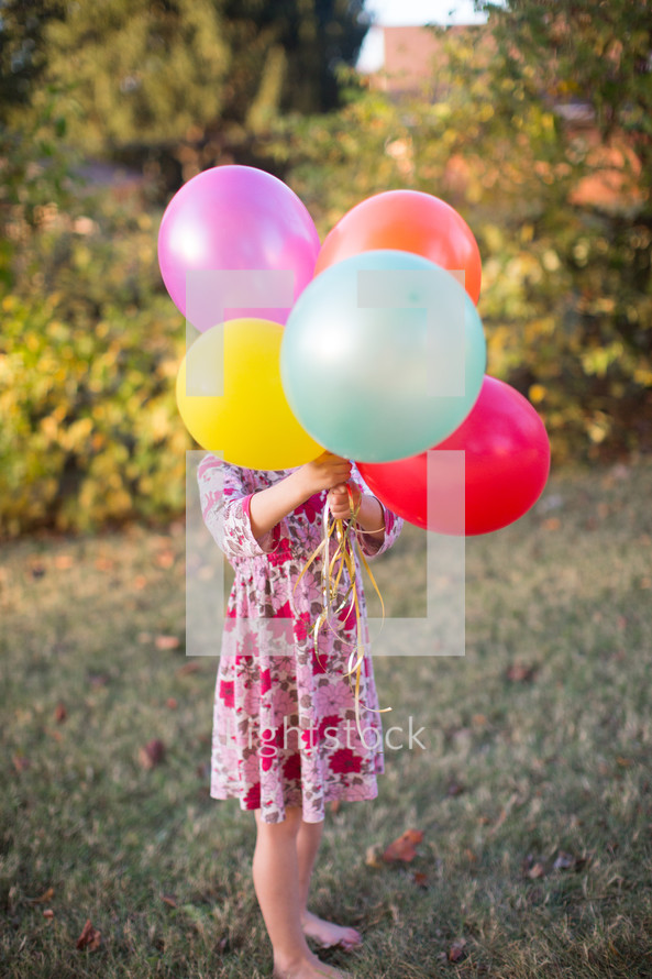 a girl holding balloons 