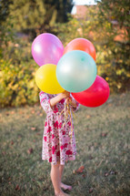 a girl holding balloons 