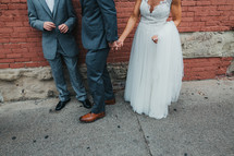 wedding party standing on a sidewalk 