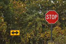 arrow street sign and stop sign 