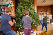 father and son's decorating a Christmas tree 