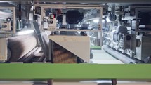 Automated wood polishing machine in a furniture manufacturing facility