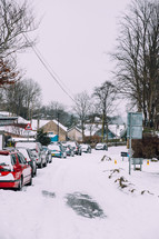 parked cars along a snow covered road 