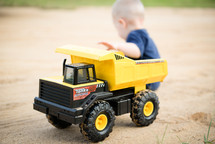 toddler boy with a toy dump truck 