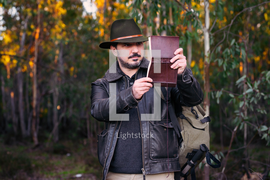 Mature man with hat and jacket with an old book 