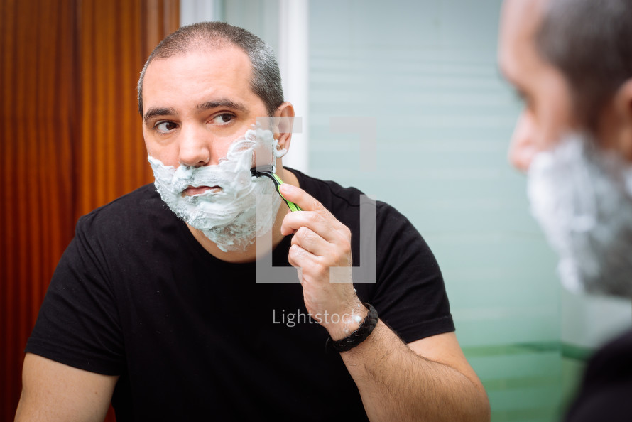 man shaves with a razor 