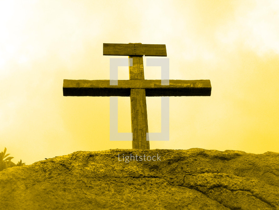The Old rugged wooden cross where Jesus was crucified at Mount Calvary or Golgotha bathed in a yellow sunlight showing victory over death, sin, hell and the grave. This is the hope that we have in Jesus Christ proving that He was the son of God overcoming death and the grave. 