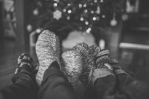 feet in cozy socks in front of a Christmas tree 