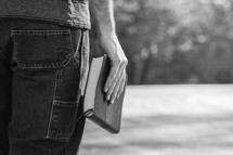 a man holding a Bible at his side 