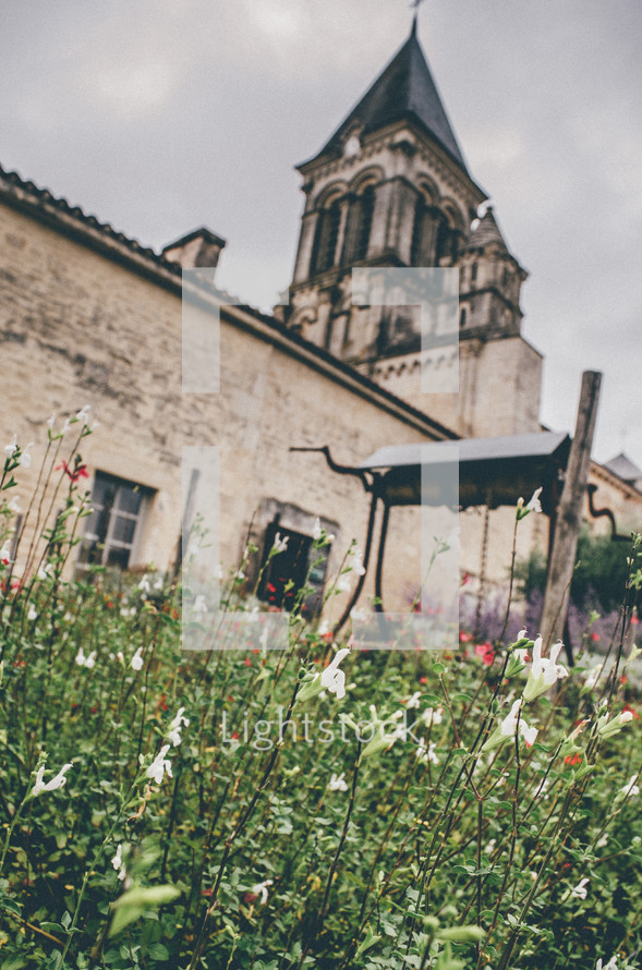 flowers and well in front of a church in France 