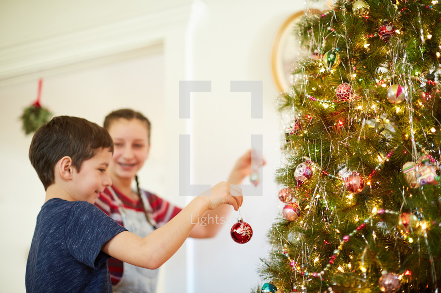children decorating a Christmas tree 