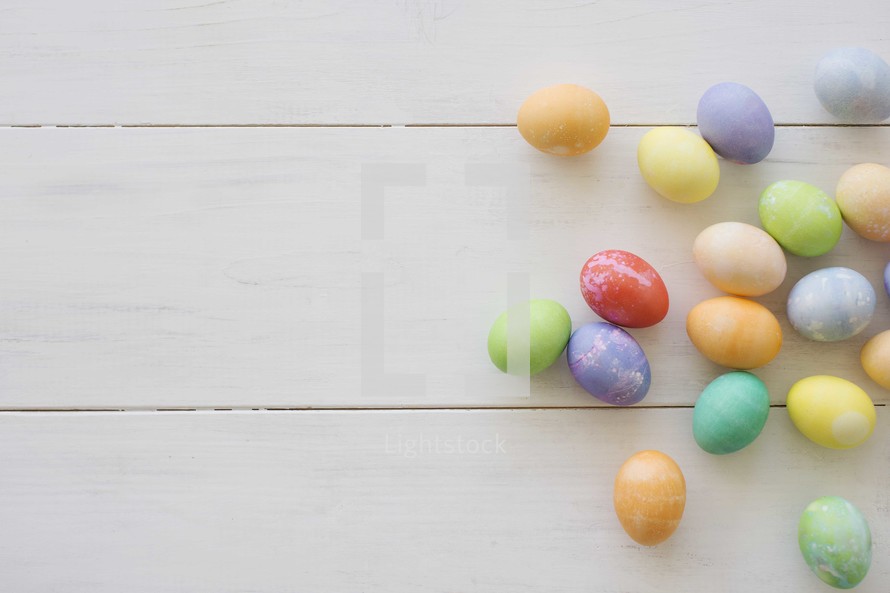 dyed Easter eggs on a white wood table.