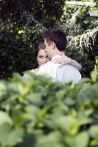 couple hugging outdoors in a garden 