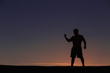 silhouette of a man making a fist 