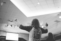 young woman inspired and standing up at a worship service 