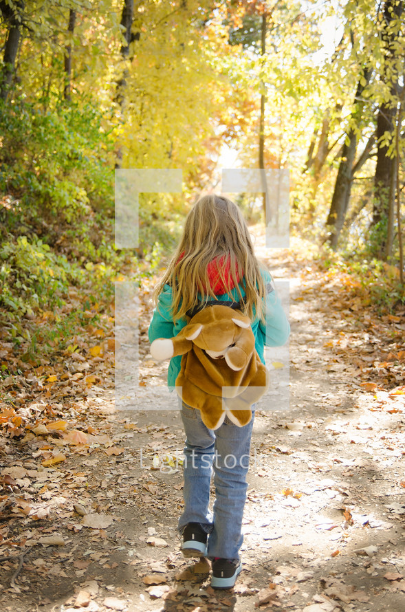 Girl walking through a forest with backpack
