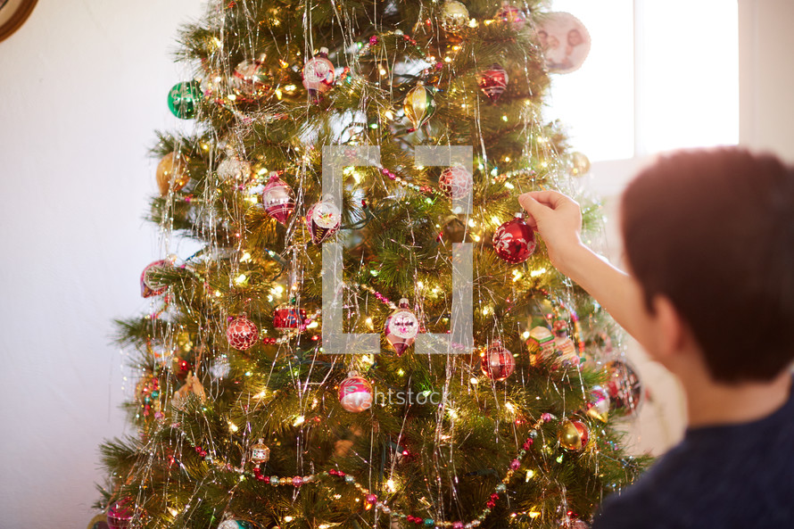 kid decorating a Christmas tree