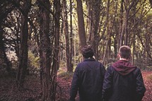 teen boys walking through a forest 