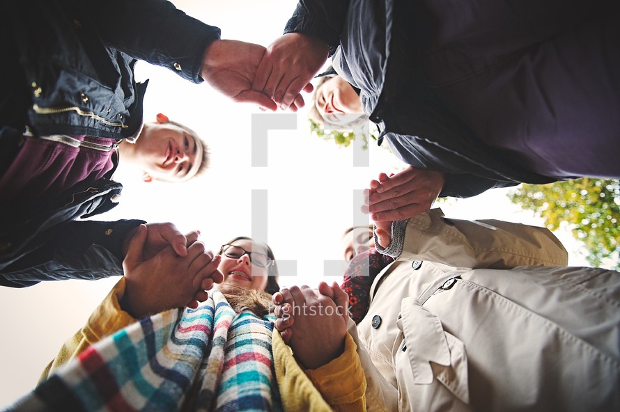 youth holding hands in a prayer circle 