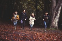 youth running through fall leaves 