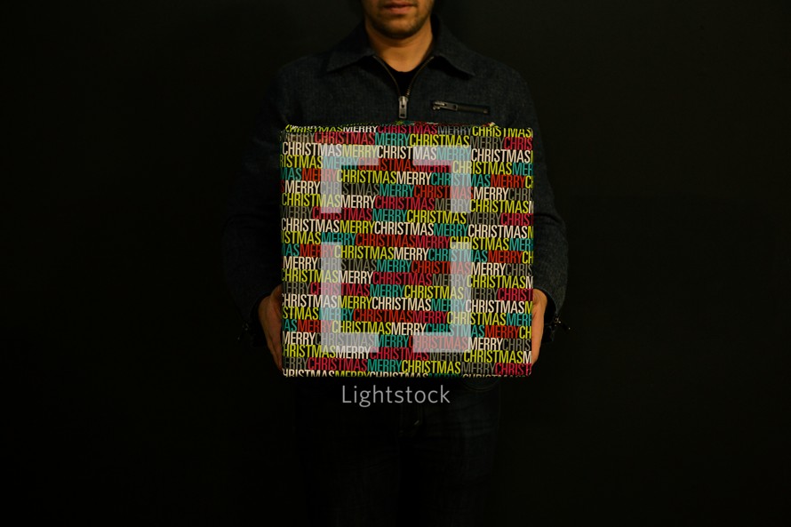 man holding a wrapped Christmas gift.