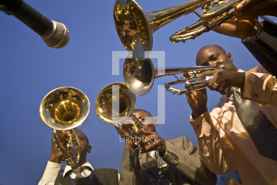Microphone pointed to musicians playing brass instruments