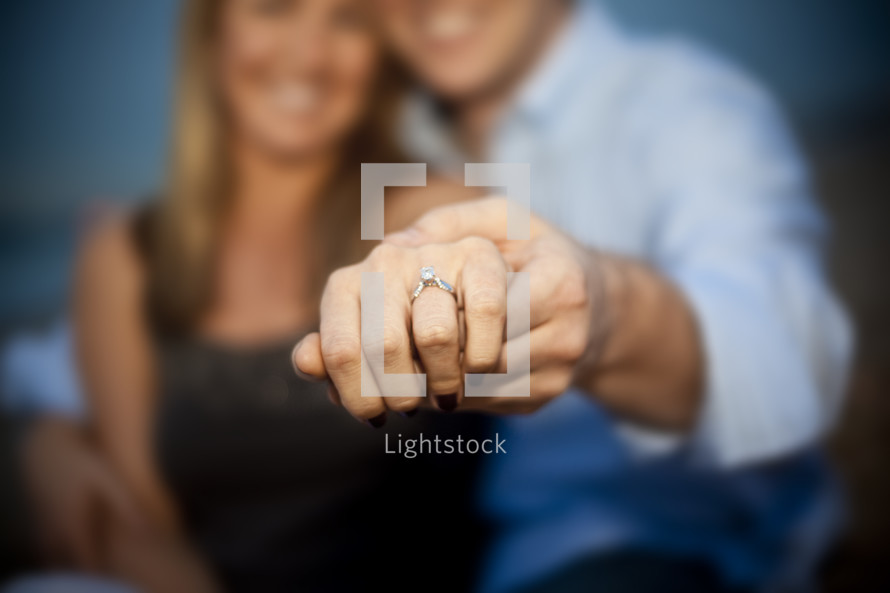Couple showing engagement ring