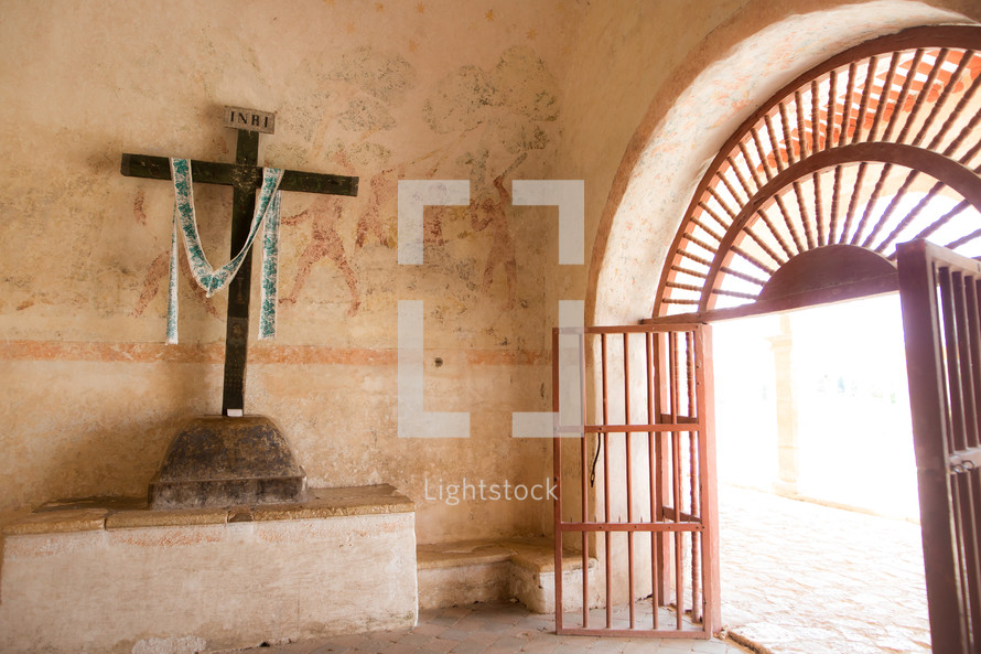 open gate and cross in a chapel 