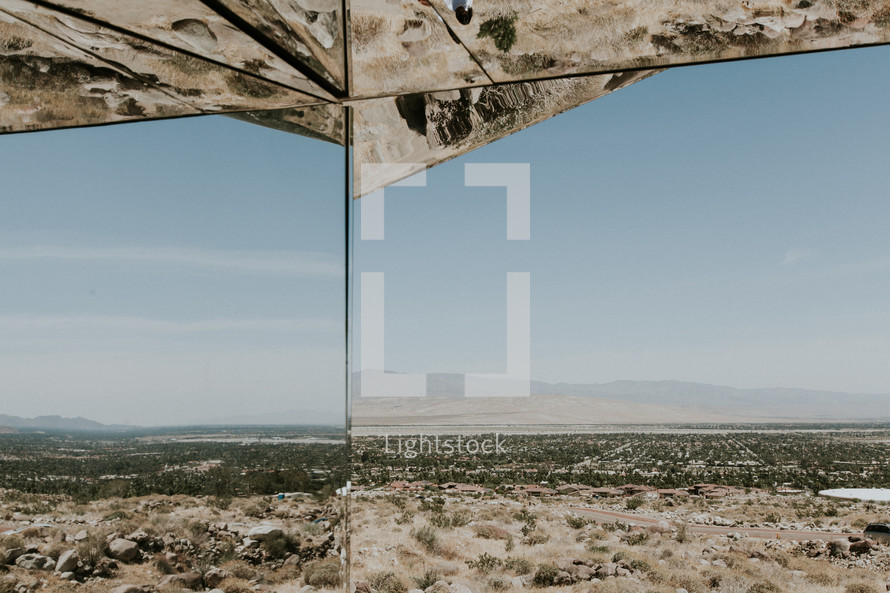 reflection of desert landscape in mirrored glass 